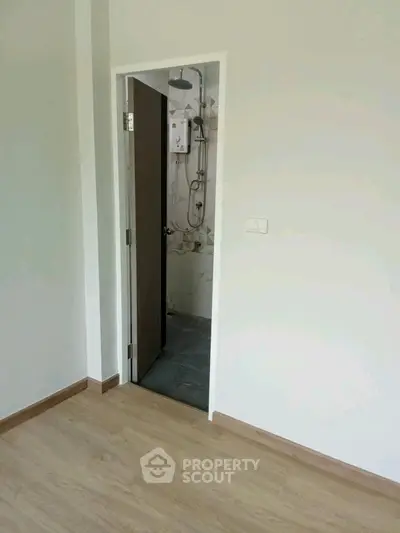 Minimalist bathroom entrance with wooden door and modern fixtures