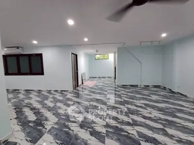 Spacious open-plan interior with modern tiled flooring and ample natural light, perfect for versatile living arrangements.