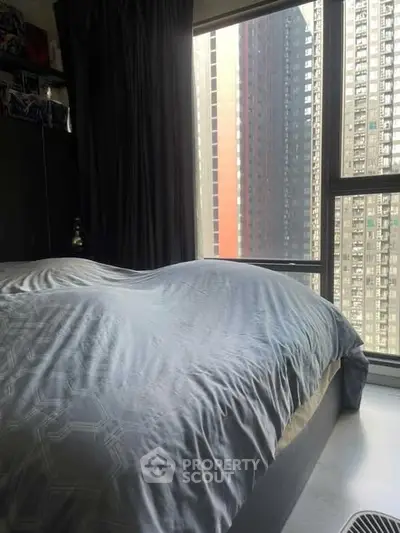 Cozy bedroom with large window offering stunning cityscape views