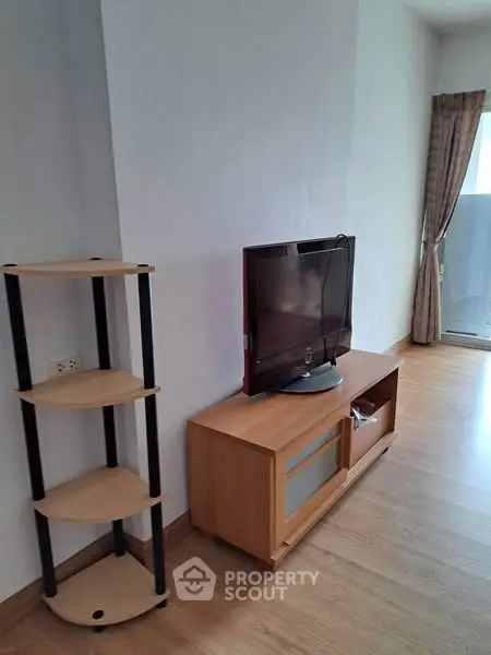 Cozy living room with modern TV stand and wooden flooring, perfect for relaxation.