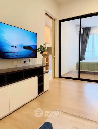 Modern living room with TV and sliding glass door to bedroom