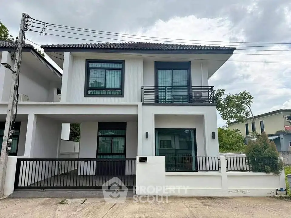 Modern two-story house with sleek design and spacious driveway in suburban neighborhood.