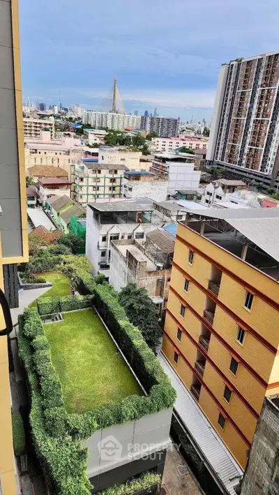 Stunning cityscape view from high-rise building with lush green rooftop garden.