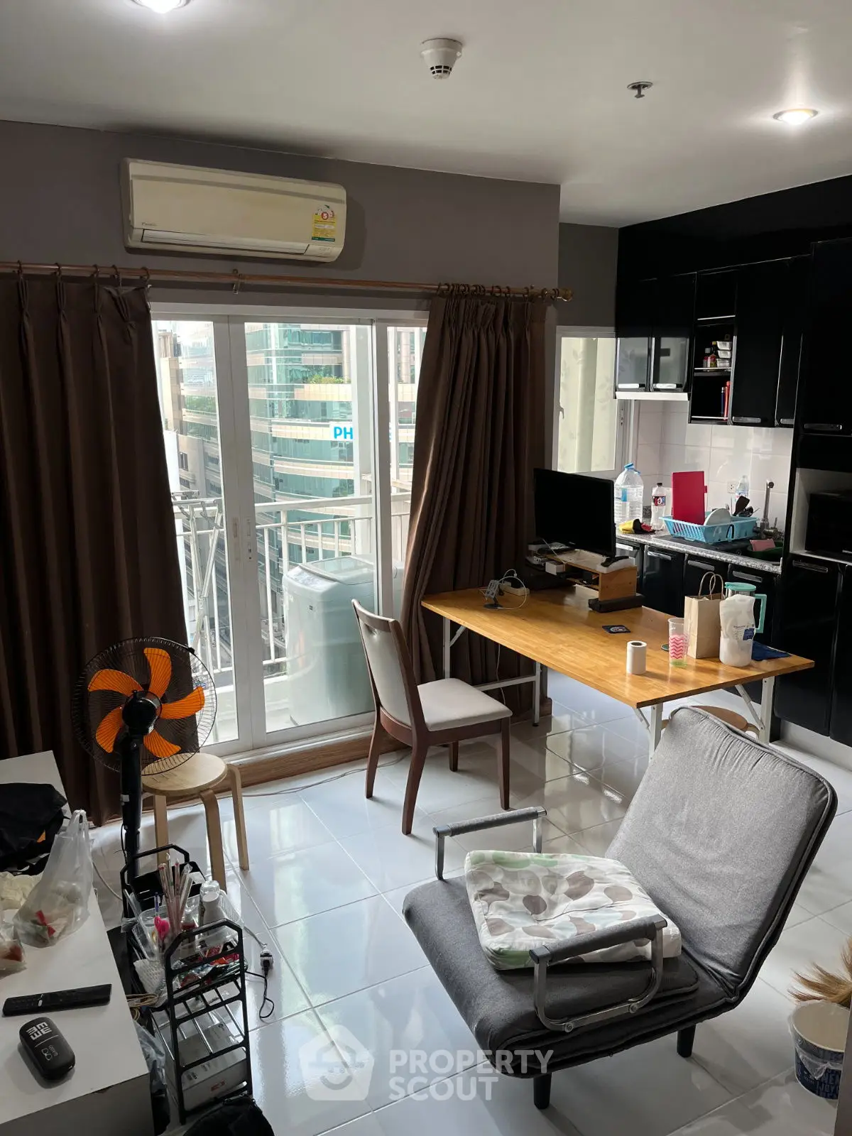 Cozy living room with balcony access and modern furnishings in urban apartment.