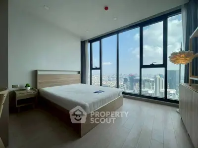 Spacious bedroom with floor-to-ceiling windows offering stunning city views.