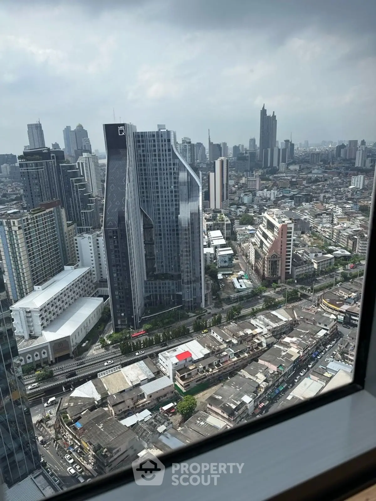 Stunning cityscape view from a high-rise building window showcasing modern urban architecture.
