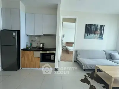Modern open-layout kitchen and living room with sleek appliances and cozy decor