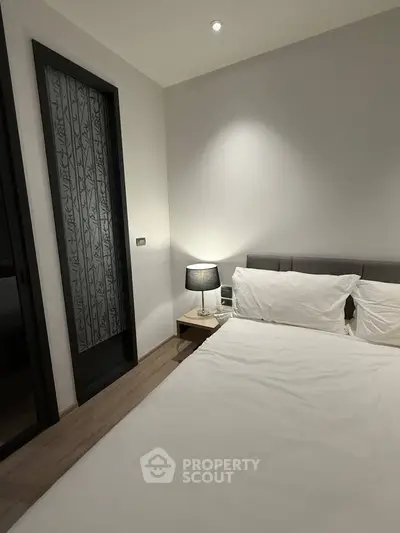 Modern bedroom with elegant decor and cozy lighting, perfect for relaxation and comfort.