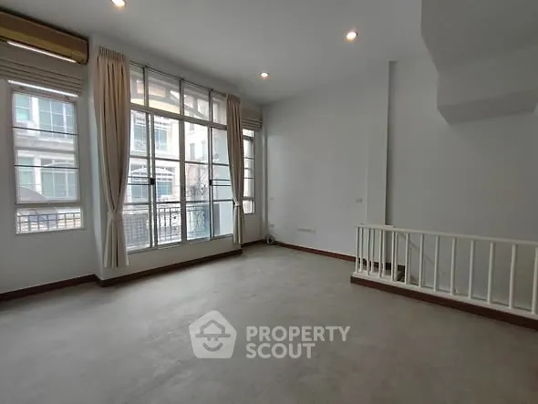 Spacious living room with large windows and natural light in modern apartment
