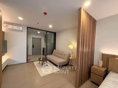 Modern living room with stylish furniture and partition, featuring a cozy sofa and elegant lighting.