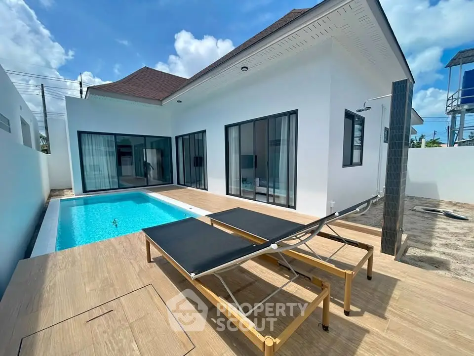 Modern villa with private pool and sun loungers, perfect for luxury living.