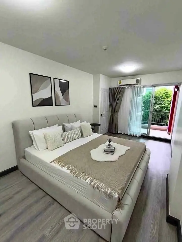 Spacious bedroom with modern decor and balcony access in a stylish apartment.