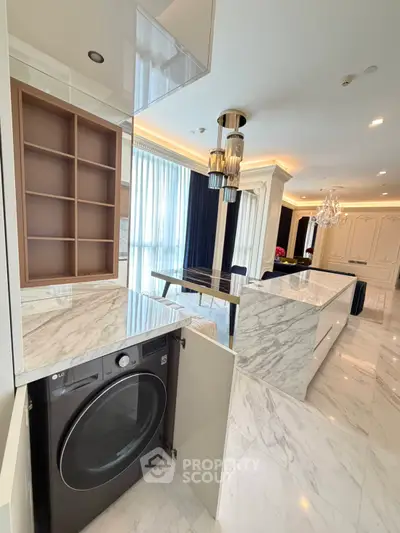 Luxurious kitchen with marble countertops and built-in appliances in a modern open layout.
