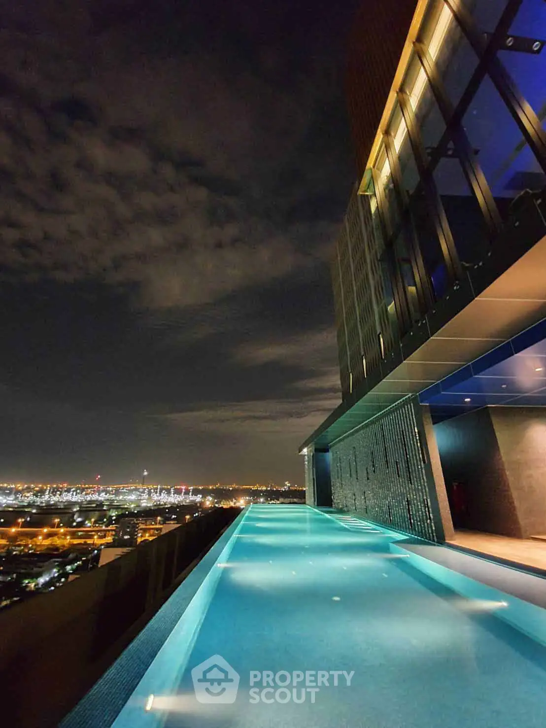 Stunning rooftop pool with breathtaking city skyline view at night.