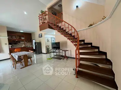 Spacious open-plan living area with stylish staircase and modern kitchen.