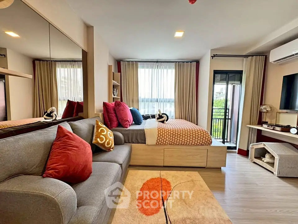Modern living room with cozy sofa, stylish decor, and large windows offering natural light.