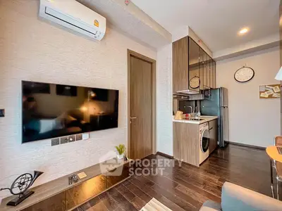 Modern living room with sleek kitchen, featuring air conditioning and stylish decor.