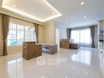 Spacious unfurnished living room with large windows and elegant ceiling lights.