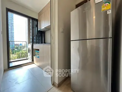 Modern kitchen with stainless steel fridge and balcony view in urban apartment