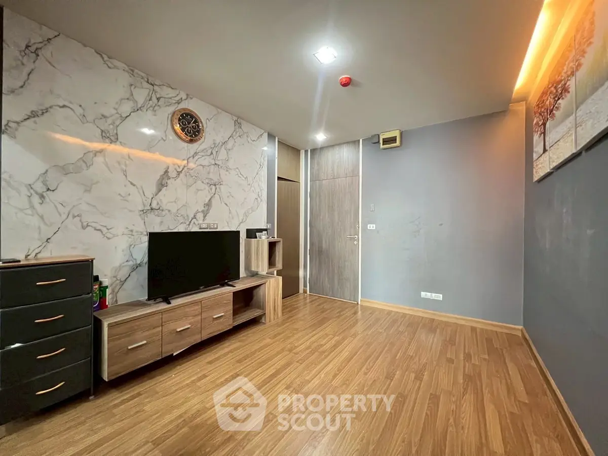 Modern living room with marble accent wall and wooden flooring
