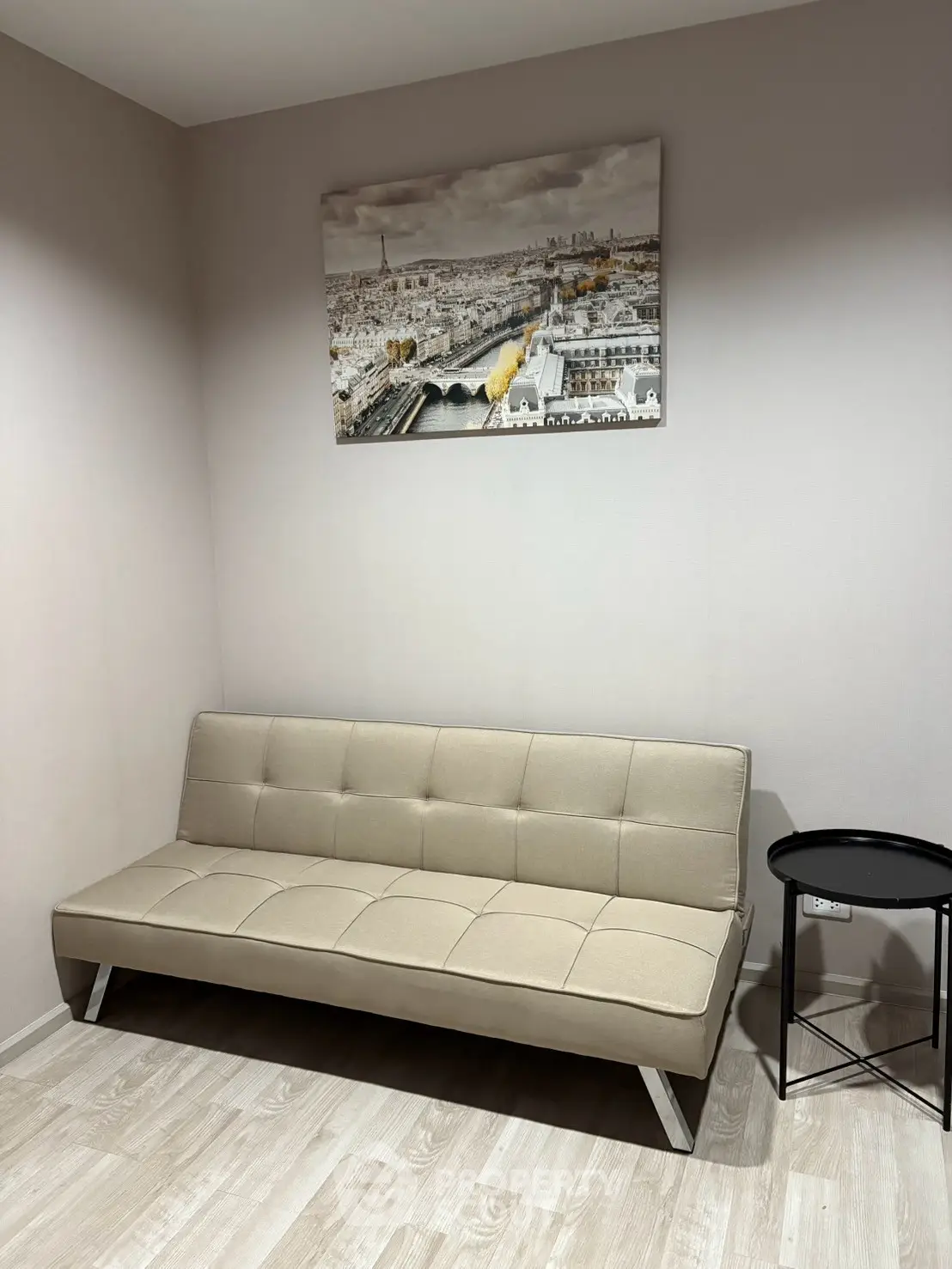 Modern minimalist living room with beige sofa and cityscape artwork