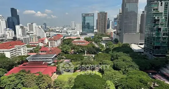 Stunning cityscape view with lush greenery and modern skyscrapers.