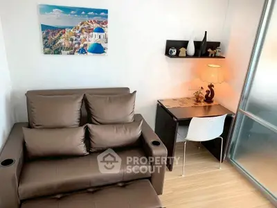 Cozy living room with stylish sofa and compact study area, perfect for modern urban living.