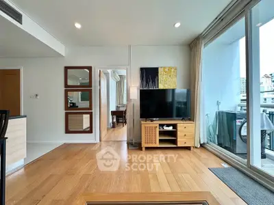 Spacious living room with wooden flooring and balcony access in modern apartment