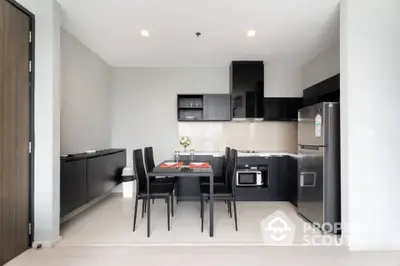 Modern kitchen with sleek black cabinets and dining area in stylish apartment