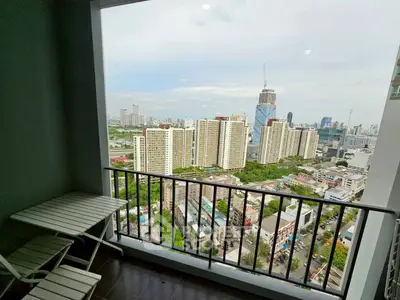 Stunning cityscape view from a high-rise balcony with outdoor seating.