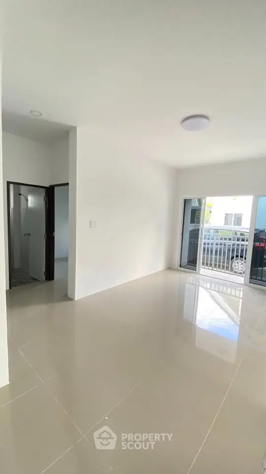 Spacious modern living room with glossy floors and balcony access