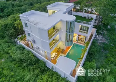 Luxurious modern villa with private pool and rooftop garden surrounded by lush greenery.