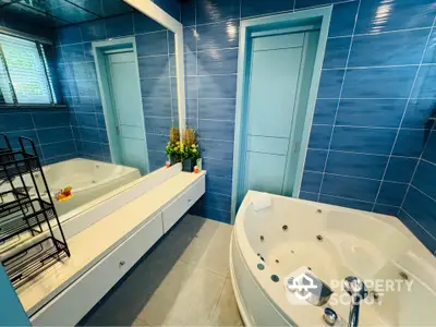 Luxurious bathroom with blue tiles and jacuzzi tub