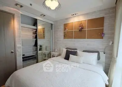 Cozy bedroom with modern decor and ample storage in a stylish apartment.