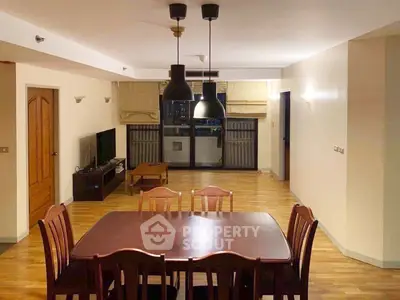 Spacious living room with dining area and modern lighting in a stylish apartment.