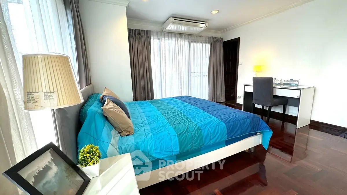Spacious bedroom with modern decor and natural light in a stylish apartment.