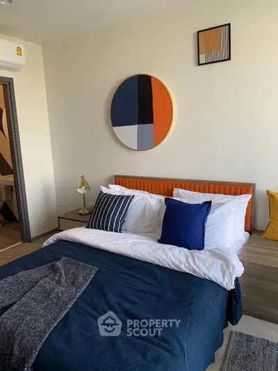 Modern bedroom with stylish decor and cozy bedding in a contemporary apartment.