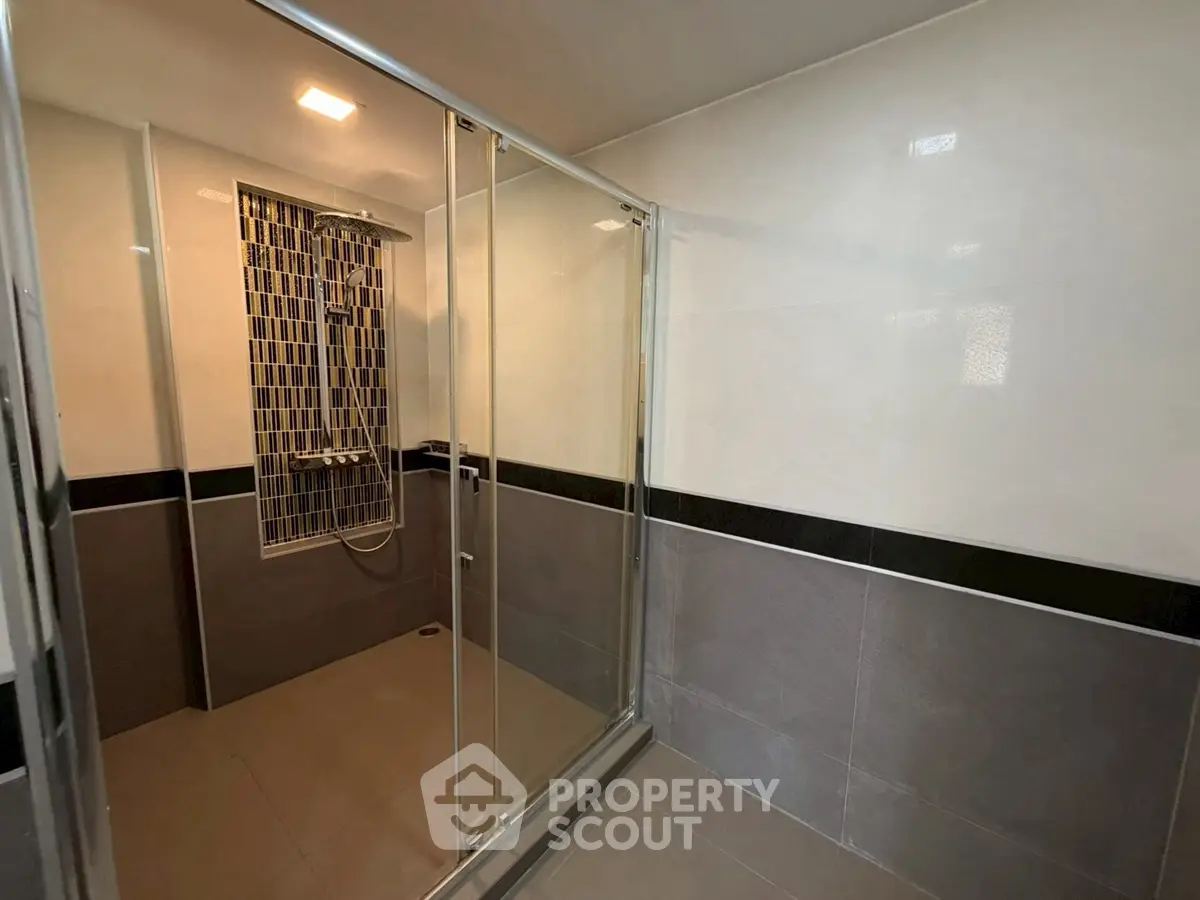 Modern bathroom with glass shower enclosure and stylish tile design