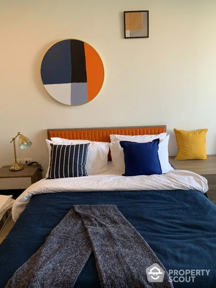 Modern bedroom with stylish decor and colorful pillows