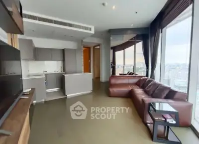 Spacious modern living room with panoramic city views and sleek open kitchen design.