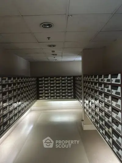 Spacious mailroom with rows of organized mailboxes in a modern building.