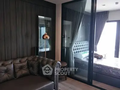 Luxurious modern apartment with stylish living room and cozy bedroom separated by glass wall.