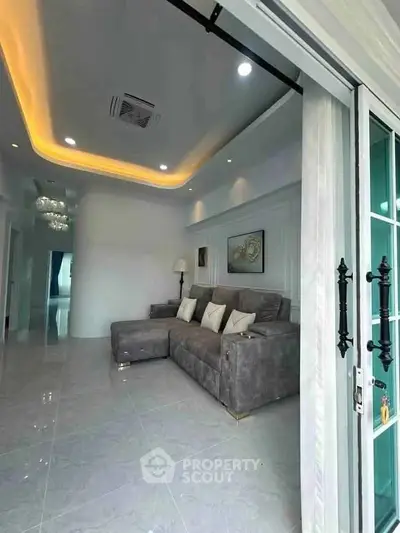 Spacious modern living room with elegant lighting and plush gray sofa
