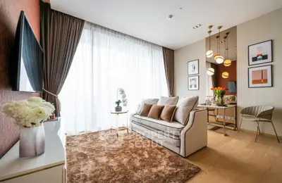 Elegant living room with modern decor, large window, and cozy seating area in a stylish apartment.