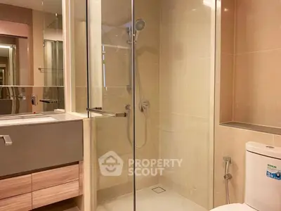 Modern bathroom with glass shower and sleek fixtures in a contemporary apartment.