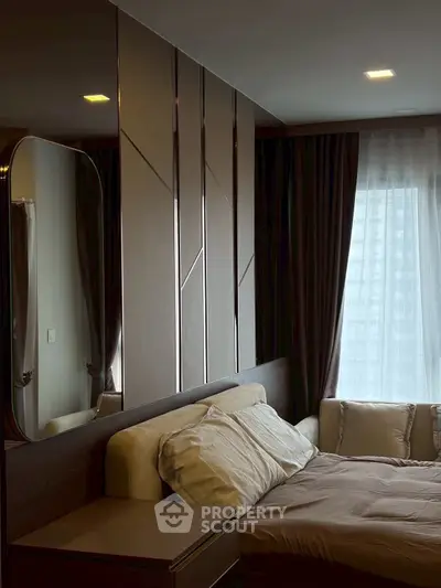 Luxurious bedroom with modern design and large window offering city view.