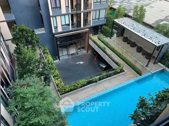 Modern apartment building with pool and lush greenery, offering a luxurious urban lifestyle.