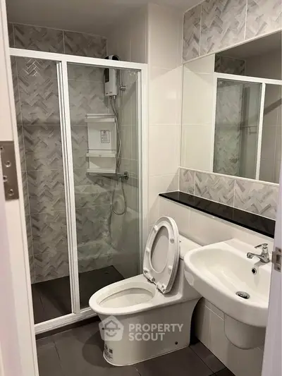 Modern bathroom with glass shower enclosure and sleek fixtures in a contemporary apartment.