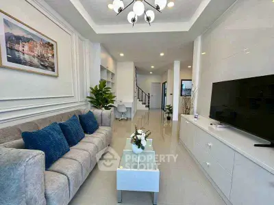 Spacious modern living room with elegant decor and large TV, perfect for relaxation and entertainment.