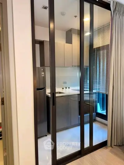 Modern kitchen with sleek design and sliding glass doors in a contemporary apartment.